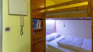 A bunk bed room with a wooden bookshelf, a whiteboard, and a telephone. - Studio cabin for 6 near ski slopes in Gourette, living room with balcony, parking (Gourette)
