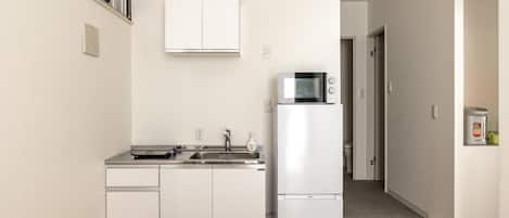 Frigorífico, microondas, placa de cocina y utensilios de cocina