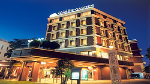 A multi-story hotel with a sign reading 'Hotel Garden' at the top.
