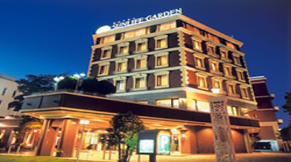 A multi-story hotel with a sign reading 'Hotel Garden' at the top.
