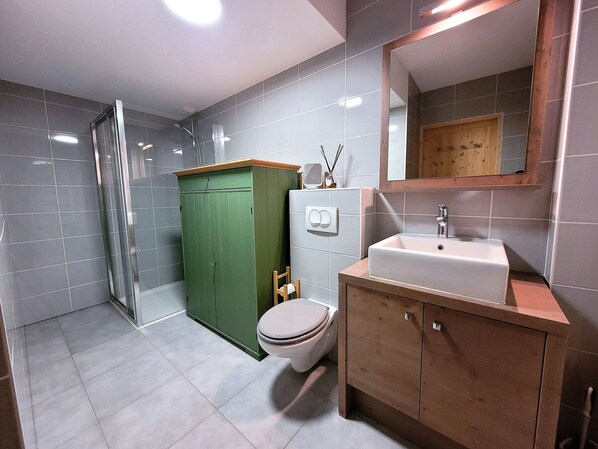 A bathroom with a toilet, sink, and shower. - Cozy Quiet Apartment with Parking and WIFI (Les Gets)