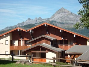 A chalet-style building with a sloped roof, wooden exterior, and multiple windows. - Cozy Studio for 4 Near Slopes with Parking and Ski Storage (Crest-Voland)
