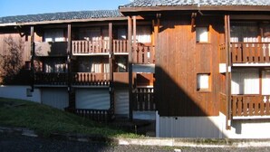 A multi-story building with balconies, wooden railings, and a tiled roof. - Cozy Studio-Mezzanine for 4 with Balcony, Near Slopes & Village – Pet Friendly (Crest-Voland)