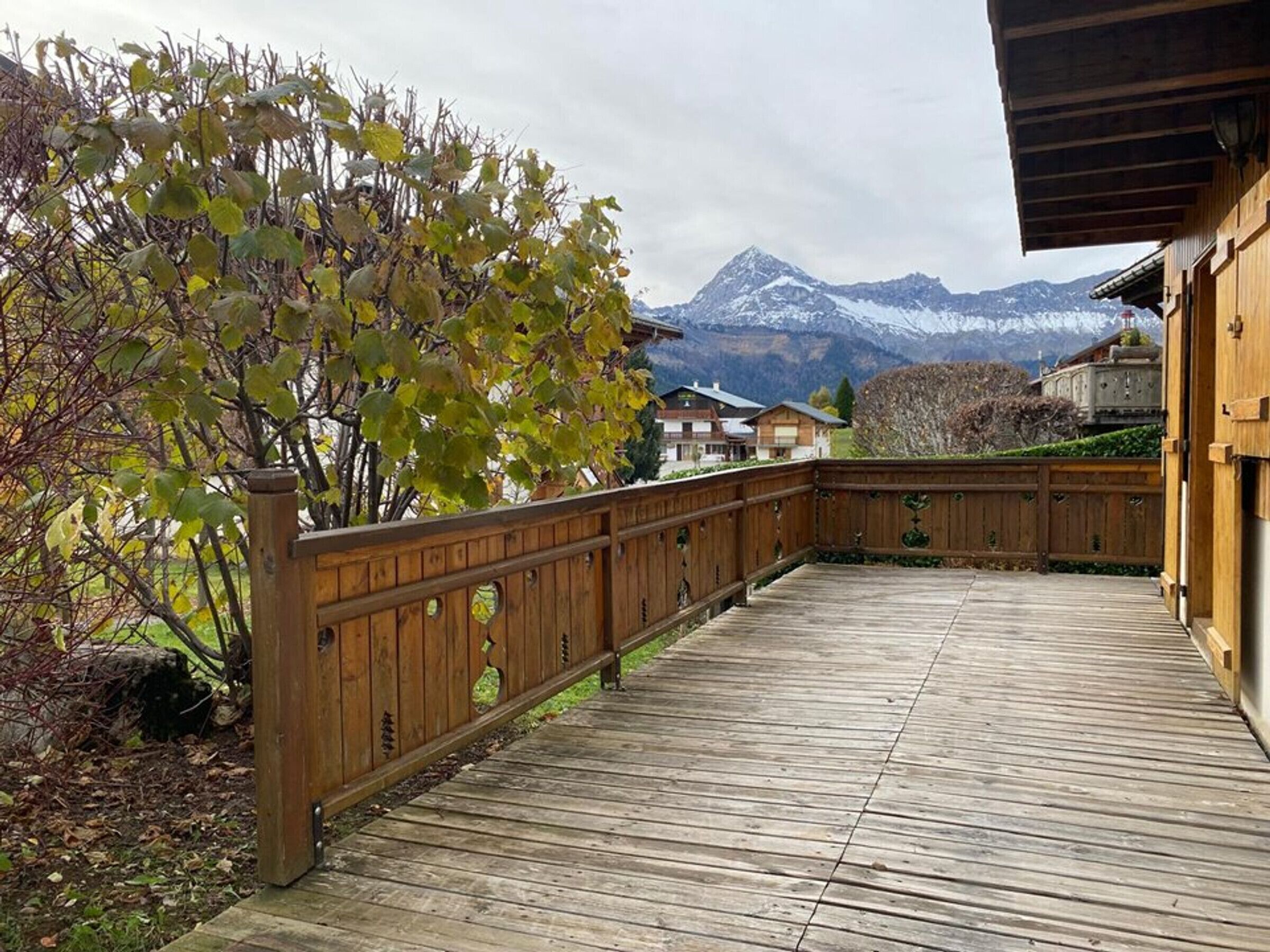 A wooden deck with a view of a mountain range.