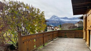 Eine Holzterrasse mit Blick auf ein Gebirge.