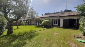 Ein Wohnhaus mit gepflegtem Rasen, einer Terrasse und einer Garage.