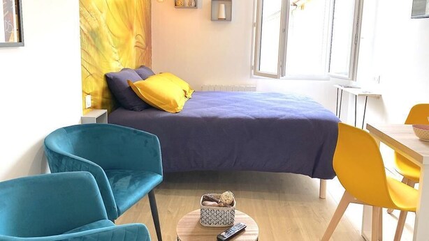 Ein modernes Schlafzimmer mit einem Bett, einem kleinen runden Tisch und einem Stuhl.