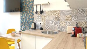 Eine moderne Küche mit Holzarbeitsplatte, einer eingebauten Spüle und einer Kaffeemaschine.
