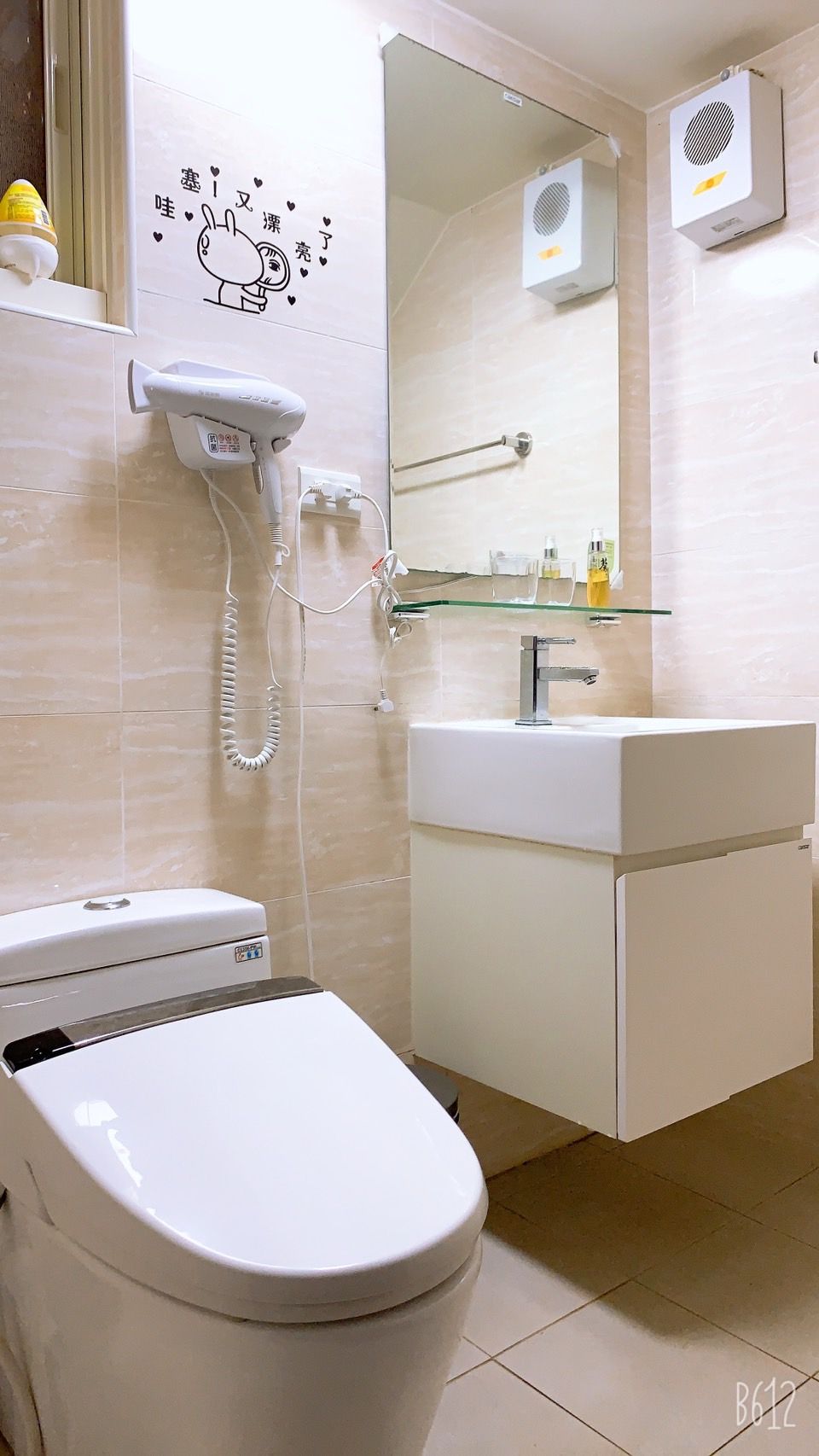 A bathroom with a toilet, a sink, and a mirror.