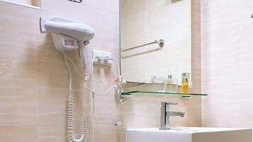 A bathroom with a toilet, a sink, and a mirror.