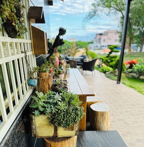 Un banco de madera con plantas en macetas y una valla blanca.