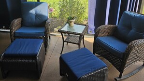 A sunroom with wicker furniture, a glass table, and a view of a garden and house. - St. John's, 3 bdrm, 2 bath, 2022 built home. 10% off military, breast cancer (The Villages)