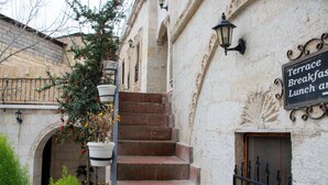 A staircase leading to a terrace with a sign indicating it is a breakfast and lunch area. - ALACA CAVE CAPPADOCIA (Nevsehir)