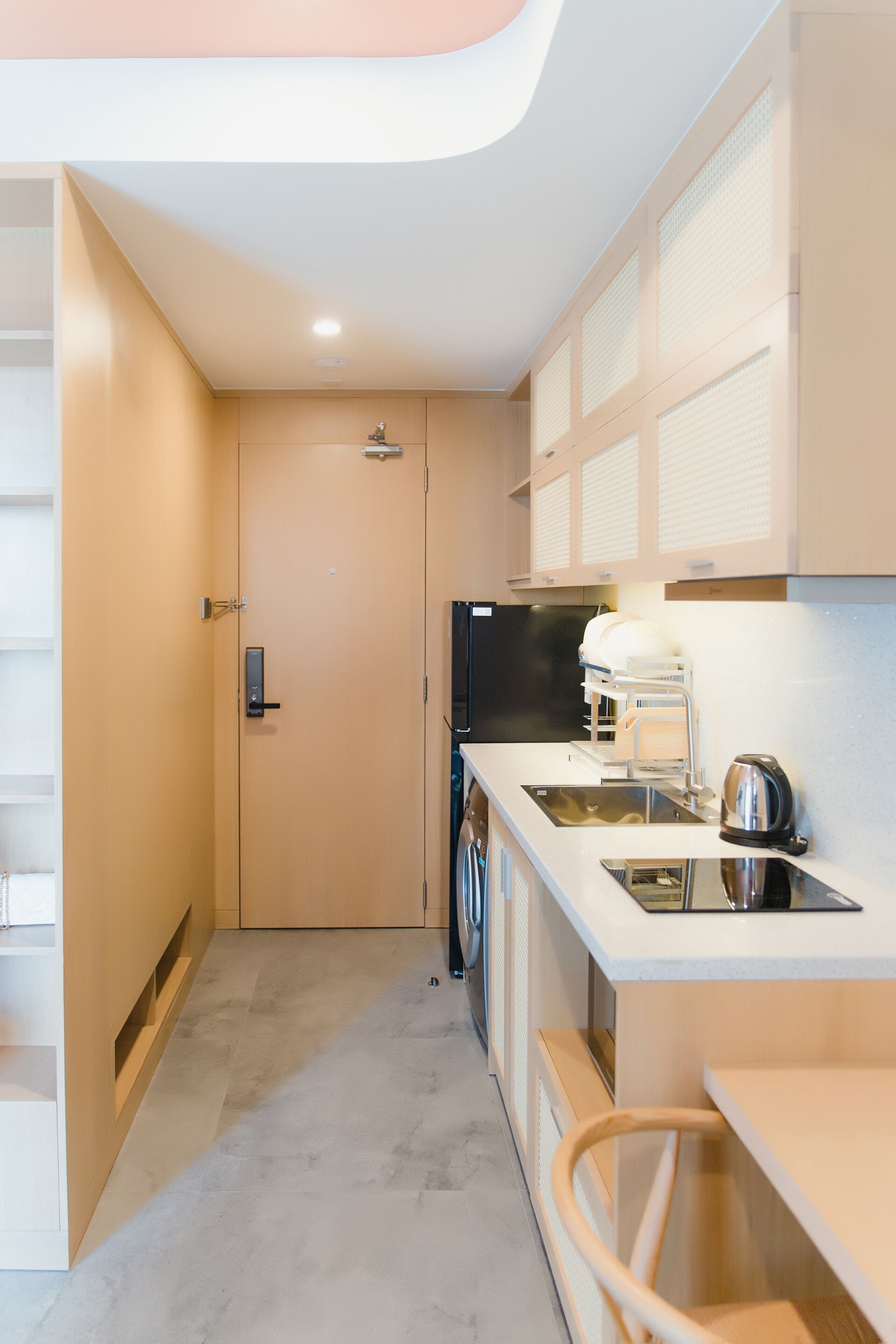 A compact kitchen with a built-in oven, a sink, and a coffee maker.