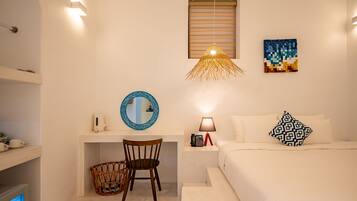 A bedroom with a bed, bedside table, lamp, and wall art.