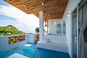 A balcony with a view of the sea, a wooden ceiling, and a white wall with a red railing. - Happiness Hotel (Quy Nhon Dong)