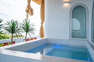 Una piscina interior moderna con agua cristalina azul, rodeada de paredes blancas y barandales rojos.