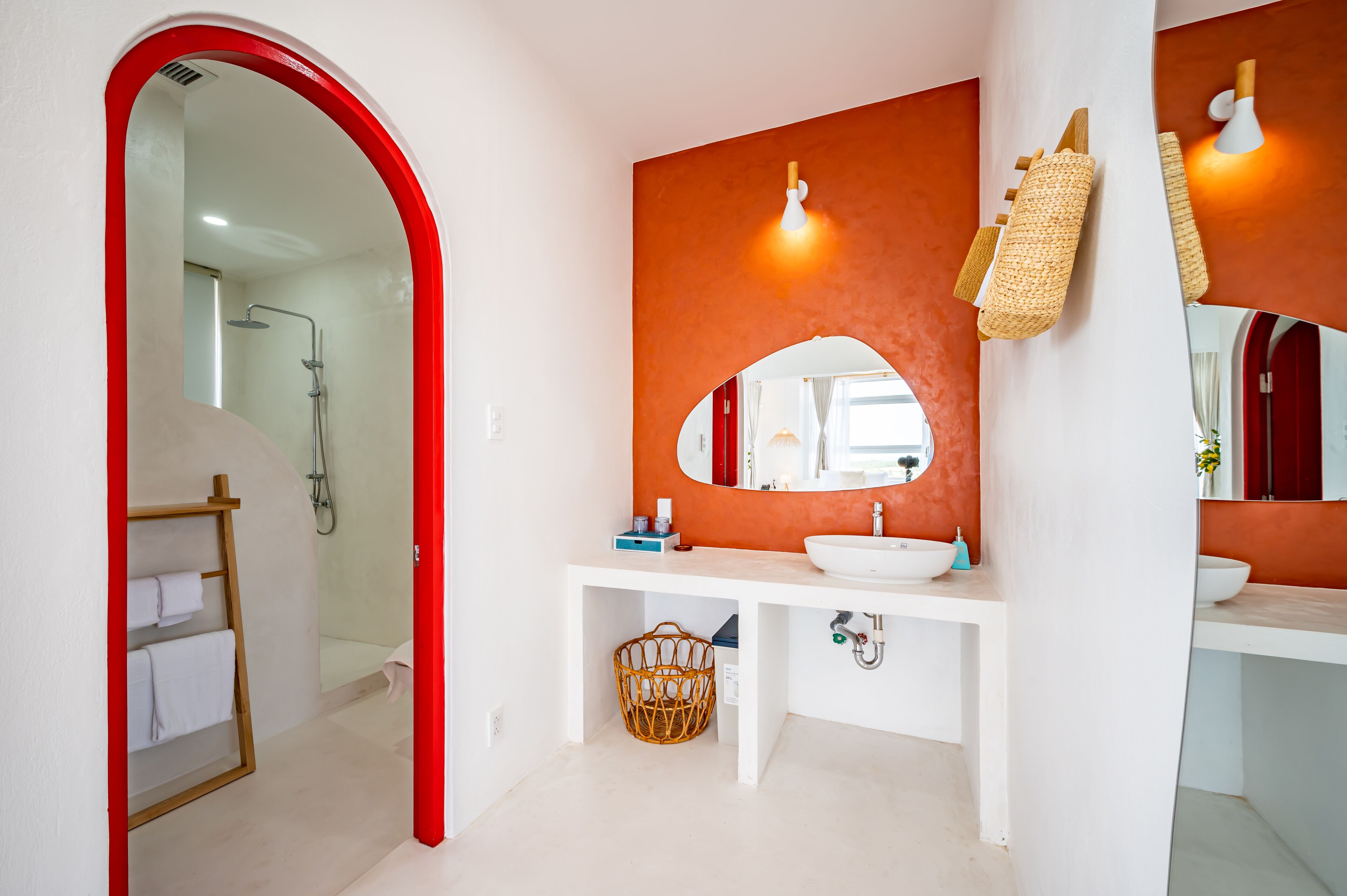 A modern bathroom with a white vanity, a large mirror, and a shower area.