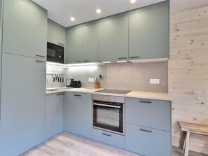 A modern kitchen with light blue cabinets, a microwave, a toaster, and a dishwasher.