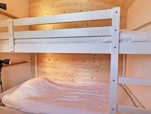 A bunk bed with white bedding in a room with wooden walls and a sloped ceiling. - Superb Renovated Duplex - Ski-in/Ski-out - Pets Allowed (Méribel)