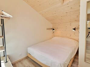 A bedroom with a wooden ceiling, a single bed, and two bedside lamps. - Superb Renovated Duplex - Ski-in/Ski-out - Pets Allowed (Méribel)