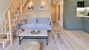 Una sala de estar moderna con sofá, mesa de centro y escalera.