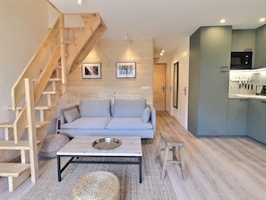 Una sala de estar moderna con sofá, mesa de centro y escalera.