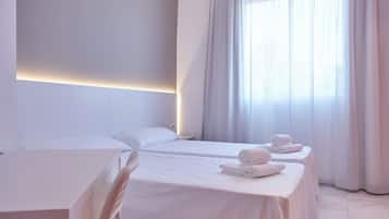 Una habitación de hotel con dos camas, un escritorio y una silla.