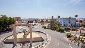 Una glorieta con un monumento central, edificios circundantes y palmeras.