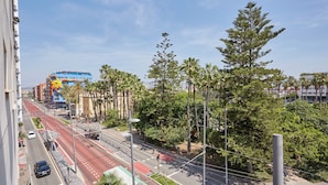 Una calle urbana con un autobús, palmeras y edificios.