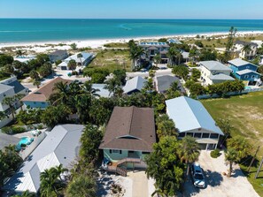 Uma área residencial costeira com casas, uma praia e vista clara do oceano.