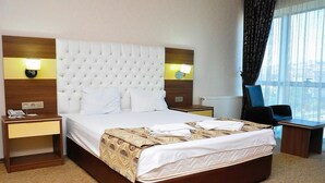 A hotel room with a large bed, two bedside tables, a desk, and a chair. - ABDULLAH RESORT OTEL (Polatli)