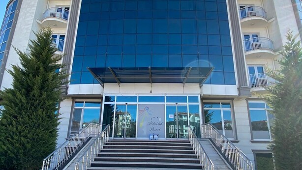 A modern hotel with a large glass facade, multiple balconies, and a central entrance with a staircase. - ABDULLAH RESORT OTEL (Polatli)