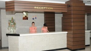 A reception desk with a sign reading "RECEPTION" above it. There are two receptionists seated behind the desk. - ABDULLAH RESORT OTEL (Polatli)