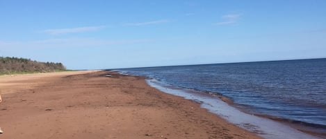 Ranta lähistöllä, aurinkotuoleja, rantapyyhkeitä