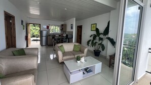 Una sala de estar moderna con un sofá, una mesita de centro y una planta grande.