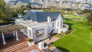 Uma casa grande e moderna com um pátio amplo e vista para montanhas.