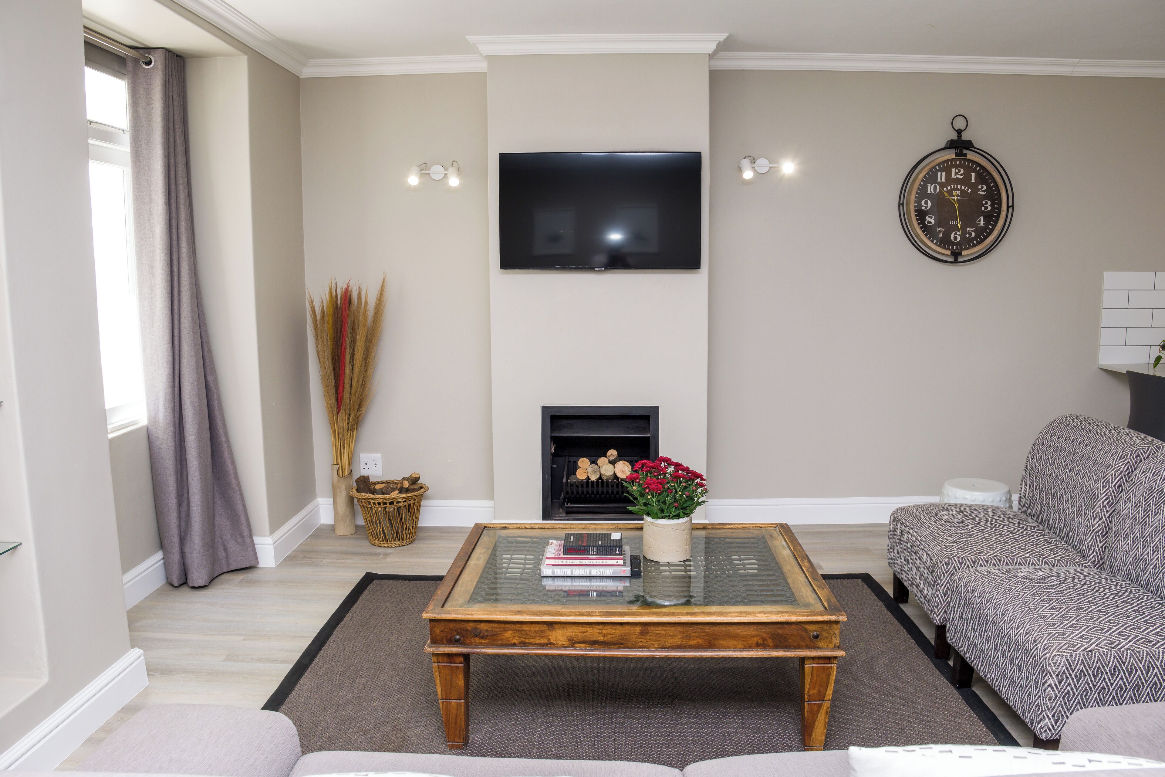 A living room with a flat-screen TV, a fireplace, a sofa, and a coffee table.
