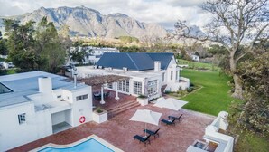 Uma casa moderna com piscina, pátio e vista para as montanhas.