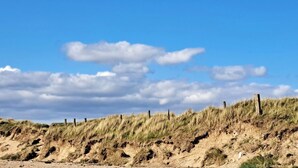 A sandy beach with dunes and wooden posts. - Apartment - Sleeps 4 - Pet Friendly - Parking (Troon)