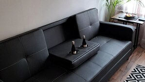 A black leather sofa with two bottles of wine on a tray. - Apartment - Sleeps 4 - Pet Friendly - Parking (Troon)
