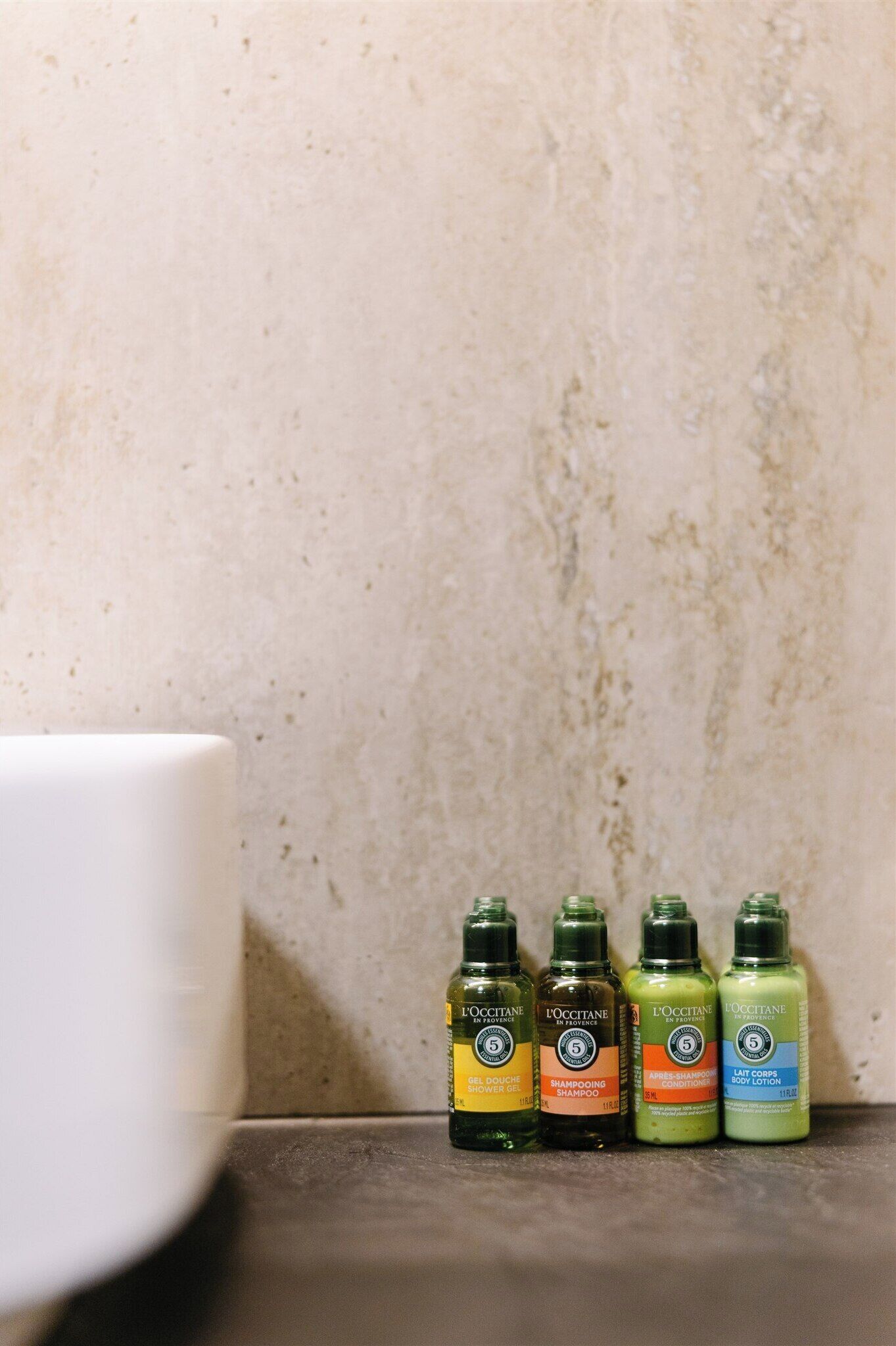 Four bottles of L'OCCITANE products on a countertop.