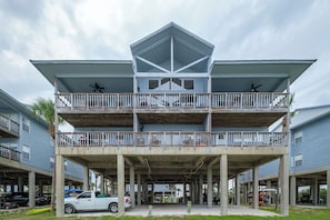 A multi-story building with a central atrium, balconies, and a covered parking area.
