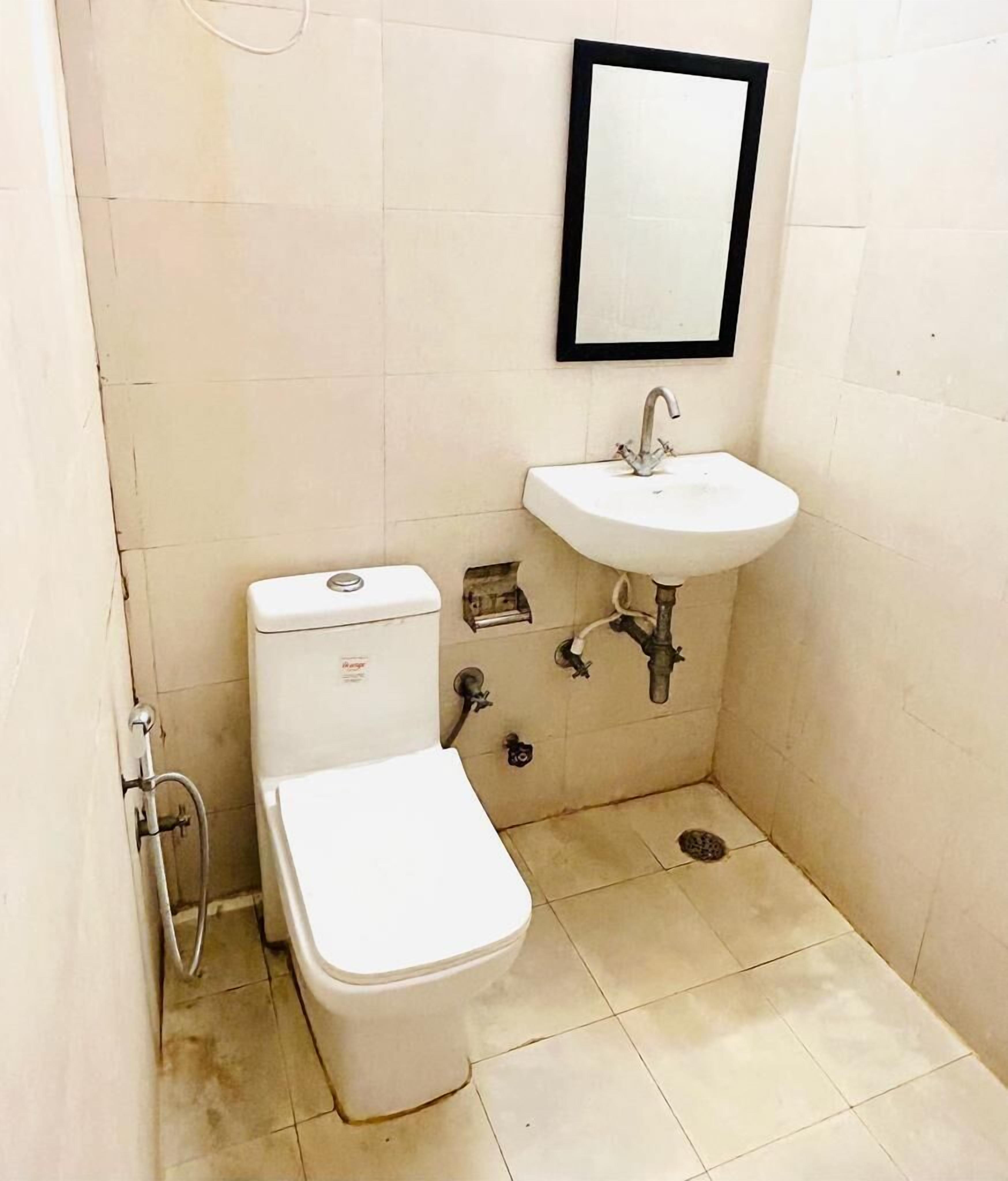 Un baño pequeño con inodoro, lavabo y espejo.