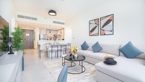 A modern living room with a sofa, coffee table, and artwork on the wall. - Vogue| Al Wasl 1 Residence near World Trade Centre (Dubai)