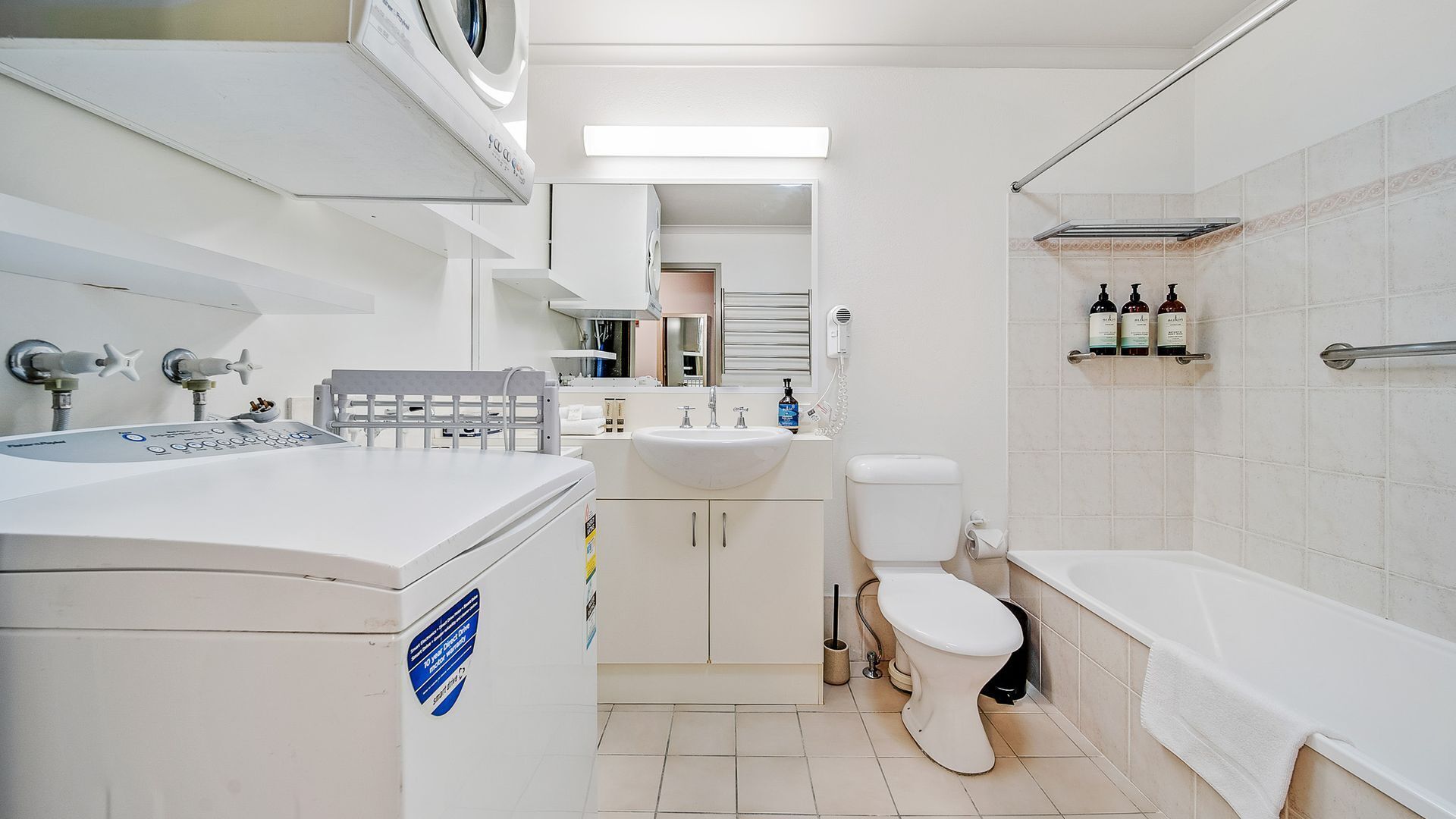 Une salle de bain moderne équipée de toilettes, d’un lavabo et d’une baignoire.