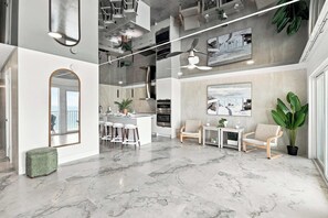 Une cuisine moderne dotée d’un îlot central, de tabourets de bar et d’un coin repas avec une table et des chaises.