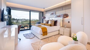 A modern bedroom with a large bed, a desk, and a view of the city. - 1 Savili - Zululami (Ballito)
