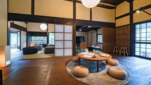 A traditional Japanese room with tatami flooring, a low table with papers, and a hanging paper lantern. - Tagomori no Akari (Ukiha)