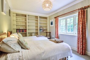 Cozy retreat with a large bed, bookshelf, and classic design.